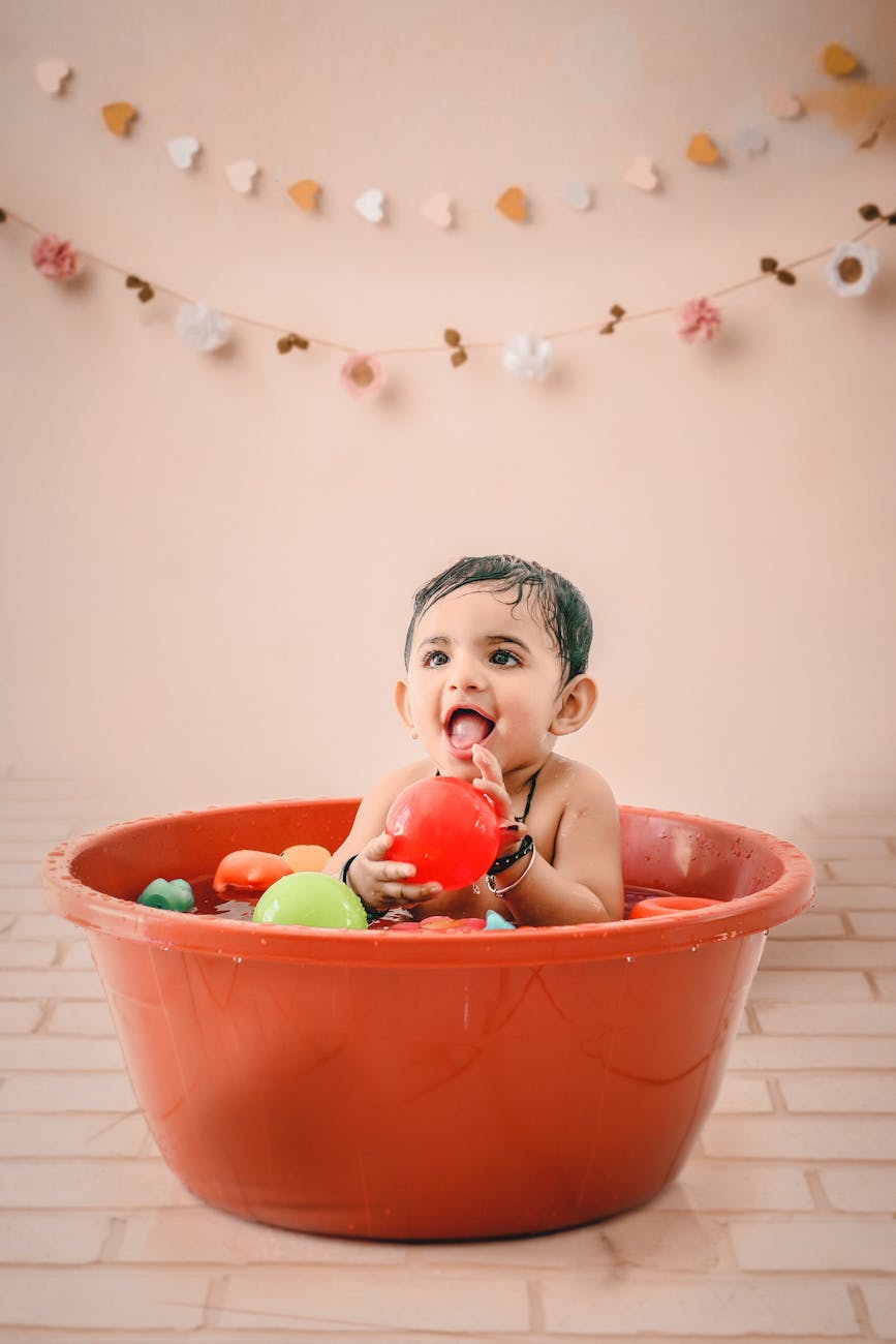 a baby boy taking a bath with balls